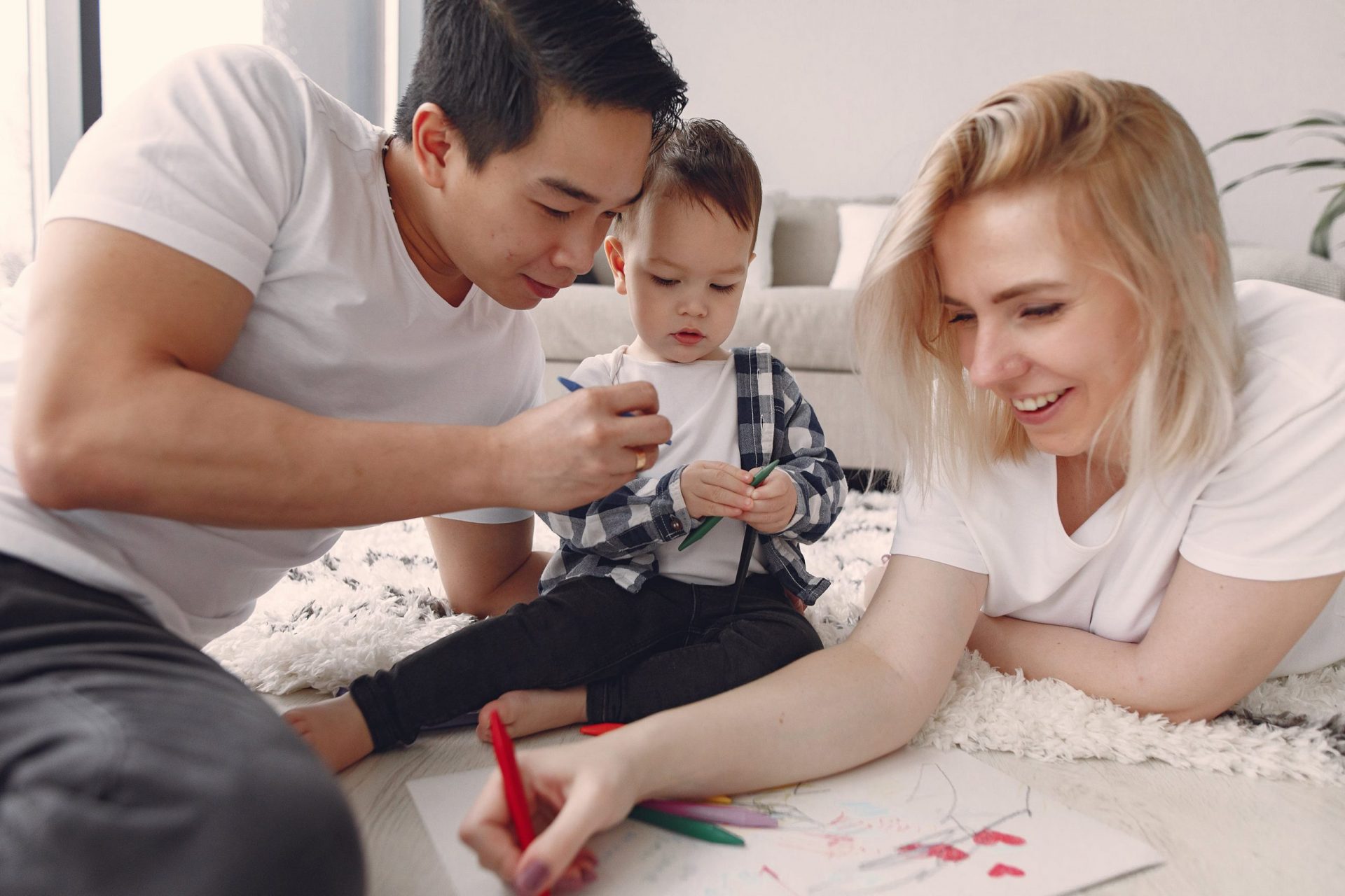 Parents and toddler drawing together