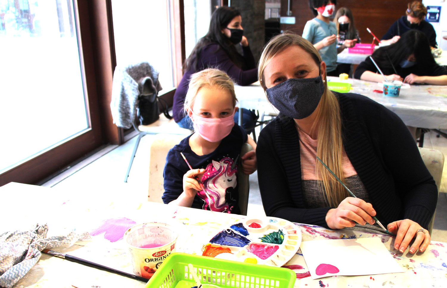 Mother and daughter creating artwork in family workshop