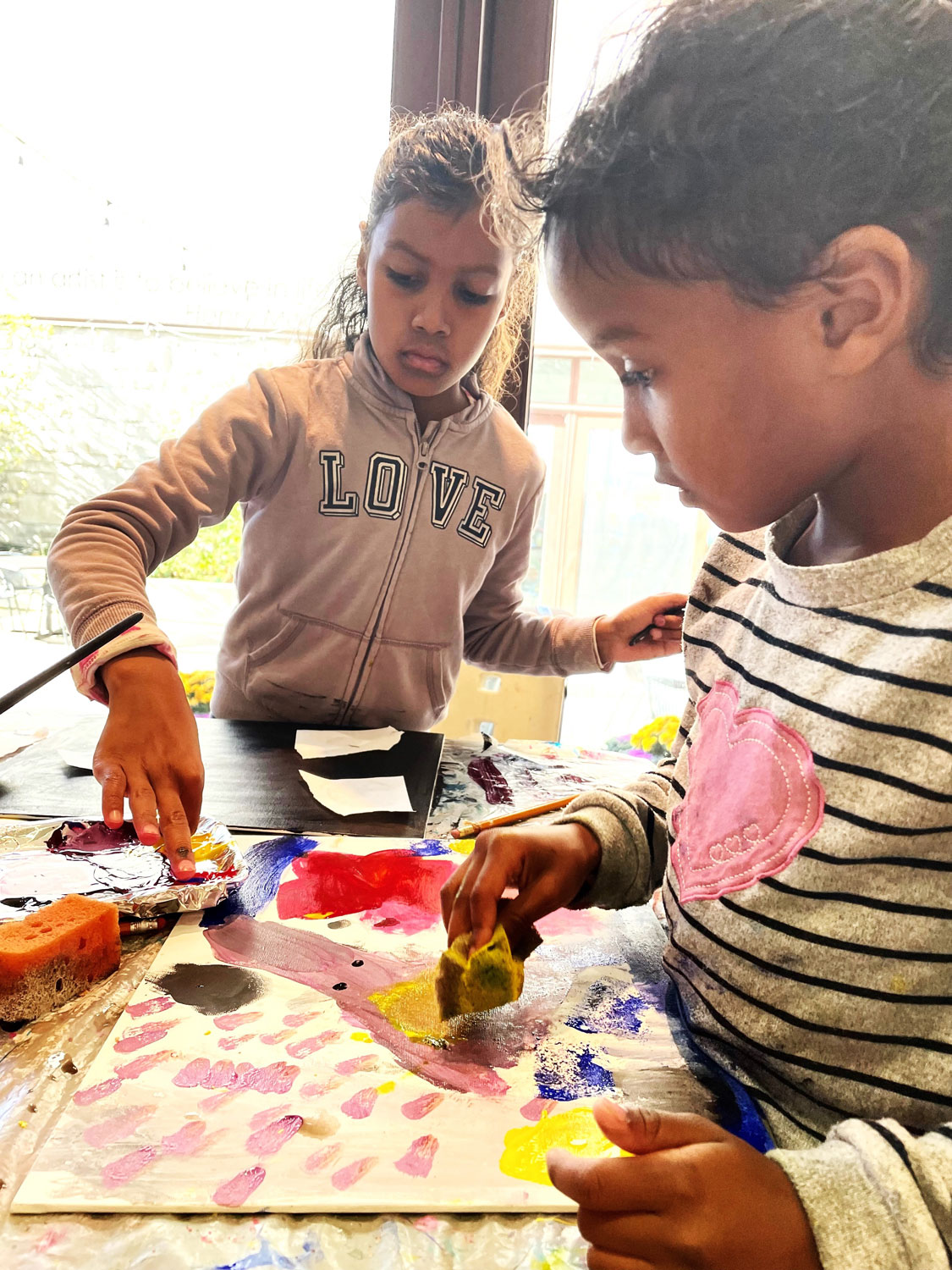 Mother and daughter creating artwork in family workshop